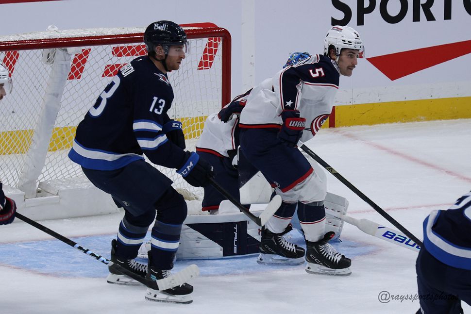 2 players skate in front of a Columbus Blue Jackets net